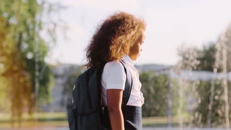 girl with backpack at fountain