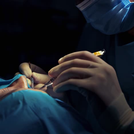 doctor doing facial correction to a woman. medical scalpel in surgeons hands during plastic surgery. blepharoplasty in clinic. close-up.