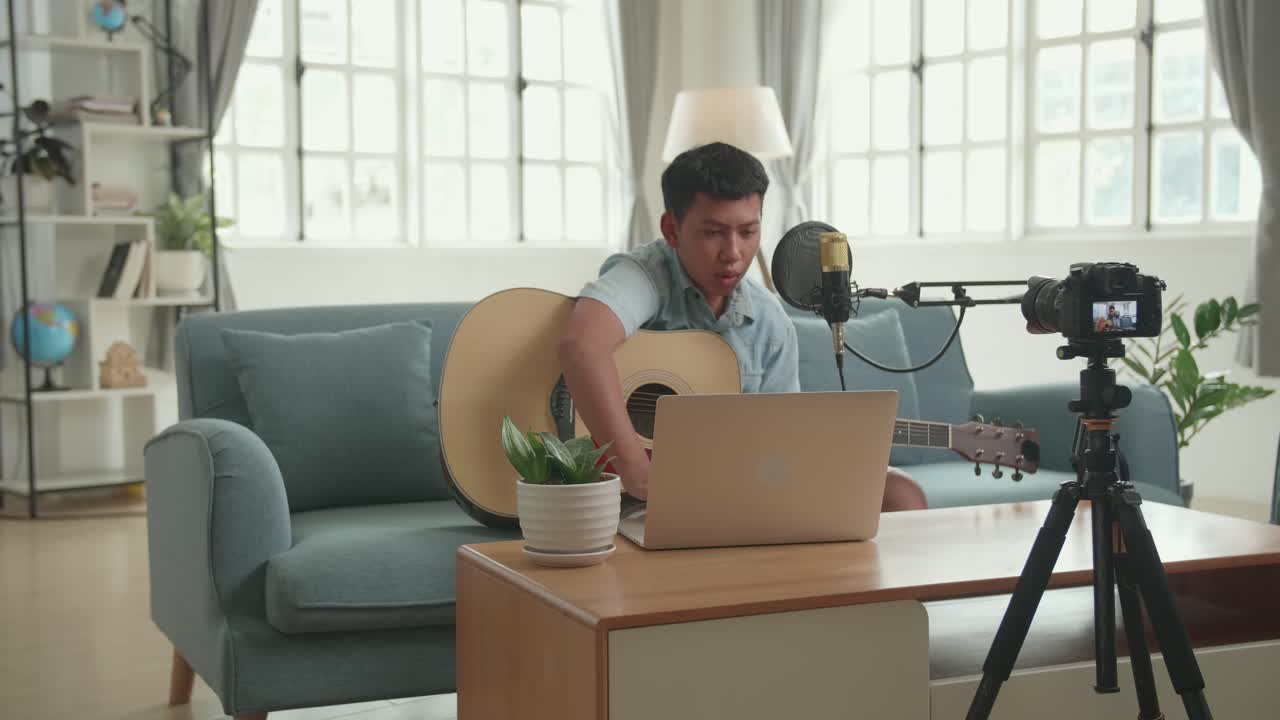 Man Playing Acoustic Guitar on Laptop for Social Media Content