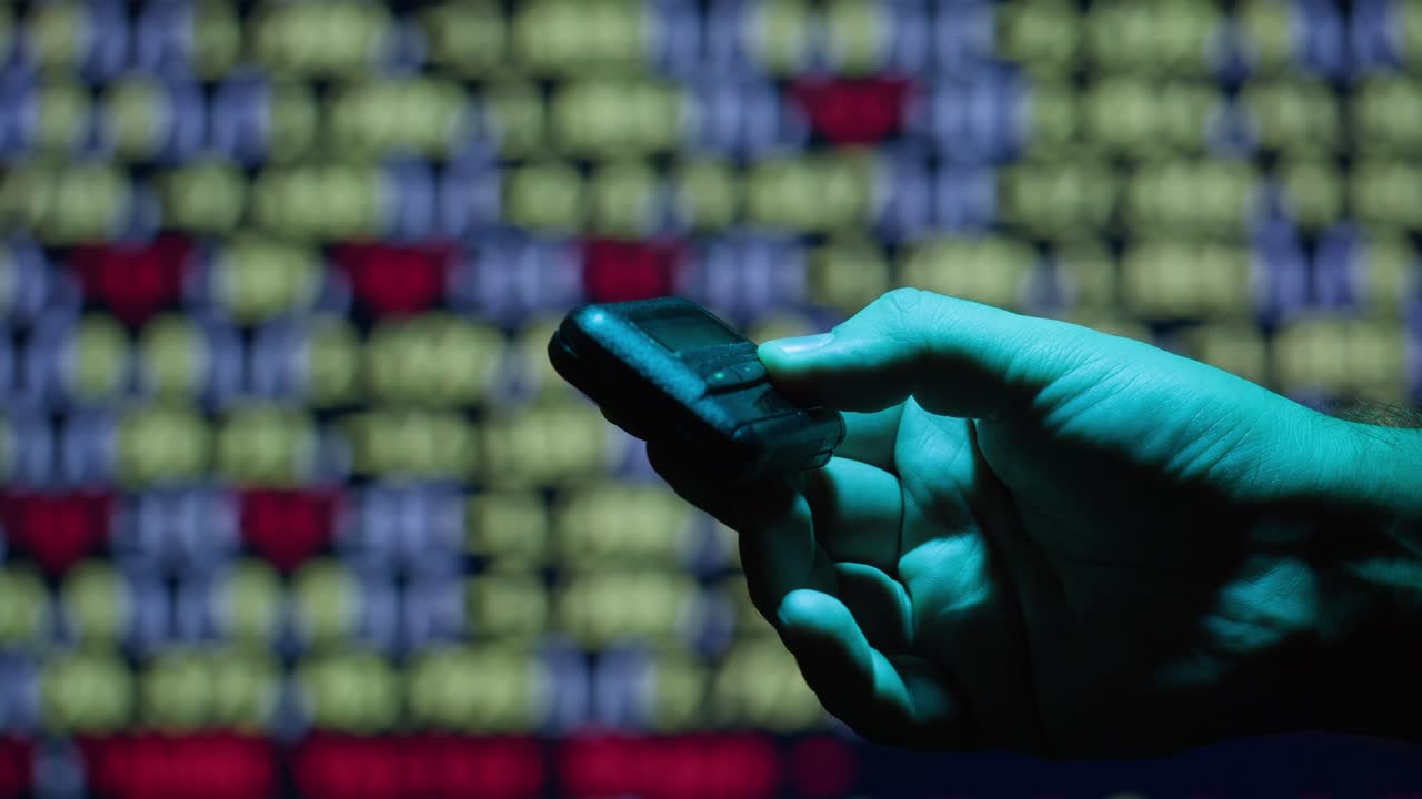 mano sosteniendo un dispositivo frente a un fondo borroso