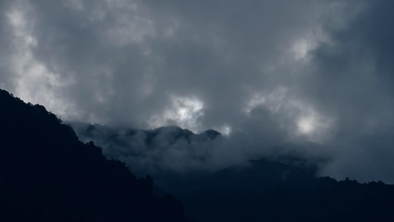 Dramatic Dark Clouds Over Mountain Ridge, Moody Blue Stormy Clouds Close Up Over Top of Mountains, Mountain Background with Copy Space