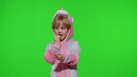 Little-child-smiling,-enjoying-eating-sweets-candies-dessert-in-unicorn-costume-on-chroma-key