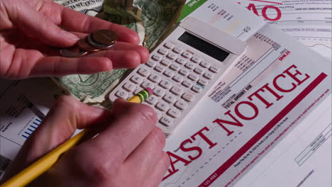 Caucasian-Woman-Calculating-how-to-pay-her-Past-Due-Bills-with-Loose-Change