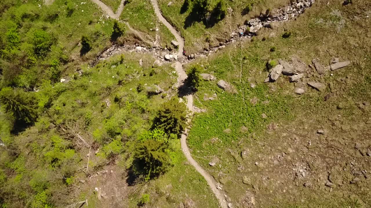 ruta de senderismo en los alpes suizos, cerca de la nieve, un arroyo y un campo de hierba