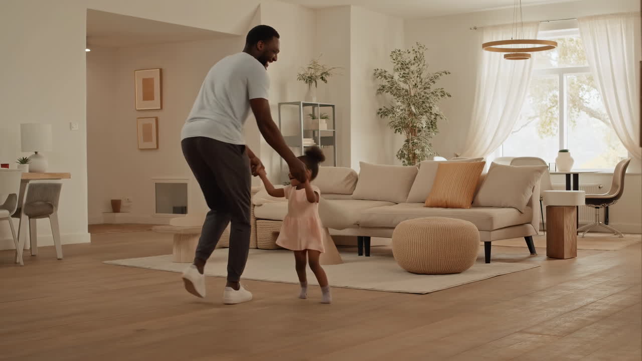 Happy Father and Daughter Playing and Dancing Together in Living Room