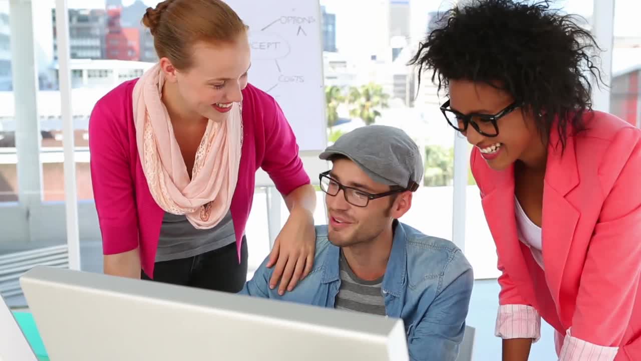 equipo creativo trabajando juntos felizmente mirando la pantalla