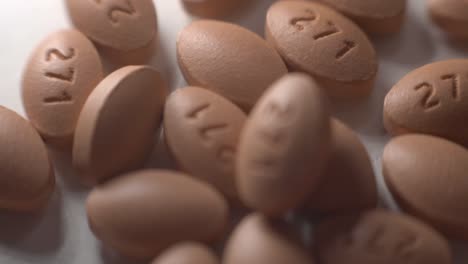 brown oval pills falling and scattered on top of a white table