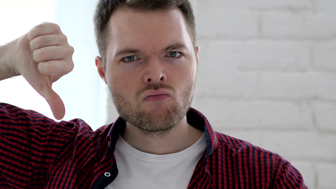 pulgares hacia abajo por un joven en el trabajo