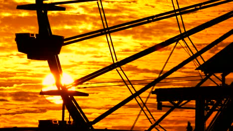 silhouette of a ferris wheel at sunrise/sunset