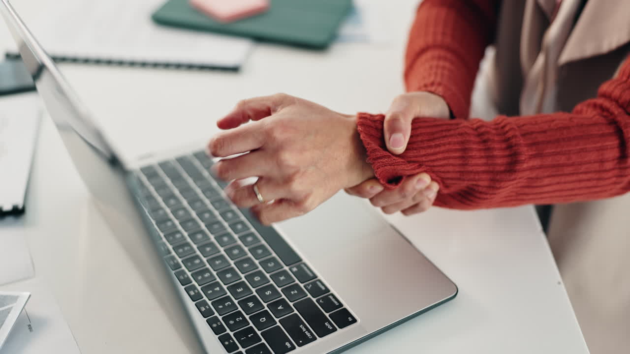 Woman experiencing wrist pain while working on a laptop