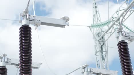 muchos aislantes eléctricos de alto voltaje en la subestación de energía contra un fondo de cielo azul
