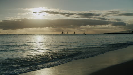 tropical beach sunset with sailboats