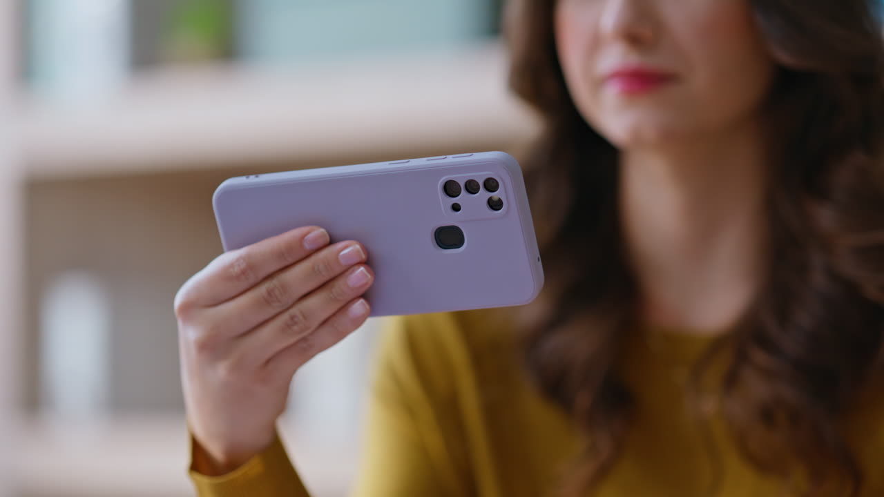 Student watching content mobile phone in apartment closeup. Woman hand holding