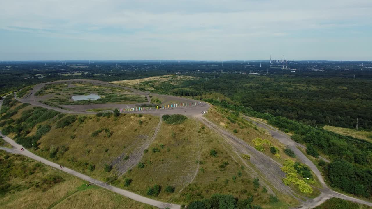 Aerial view of a hill landscape with trees and a path