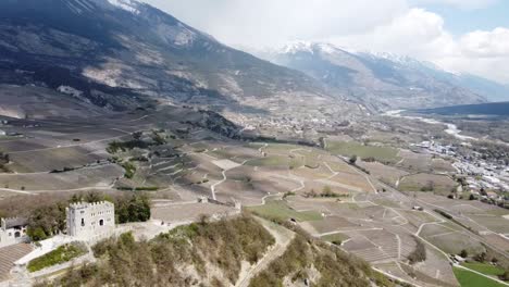 Pequeño-Castillo-En-Medio-De-Un-Valle-Verde-En-Suiza,-Con-Sombras-De-Las-Nubes