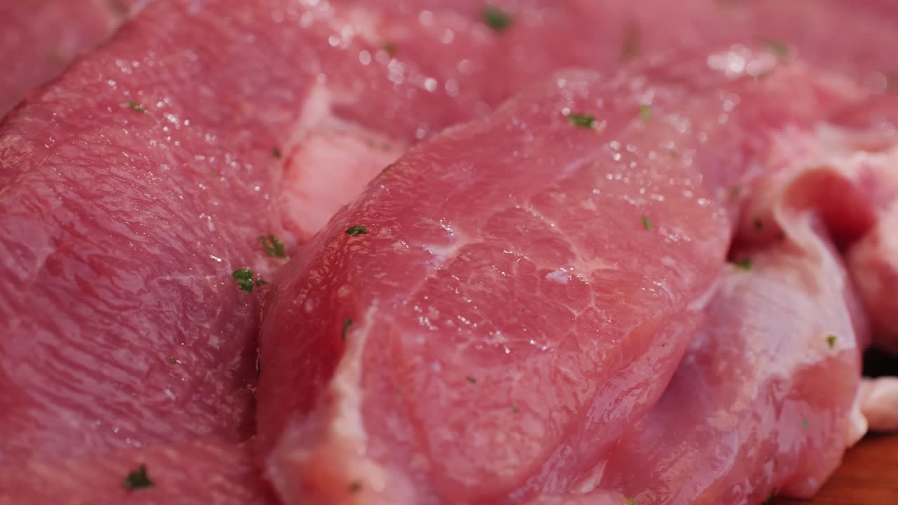 Raw slice beef meat in spices: paprika, salt, pepper, turmeric on plate close-up. Preparing raw food for cooking. Grill and Fry beef, pork, chicken, duck, turkey kebab with vegetables.