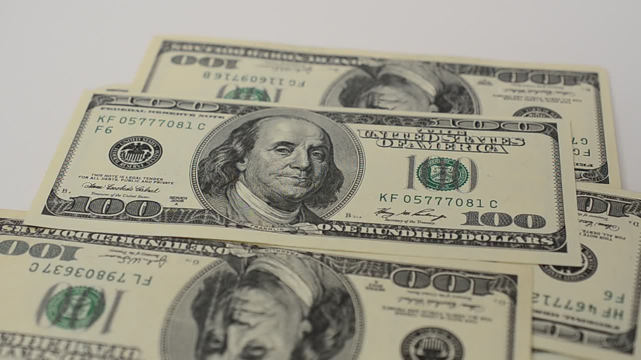 Dollari su sfondo bianco. Riprese in movimento.