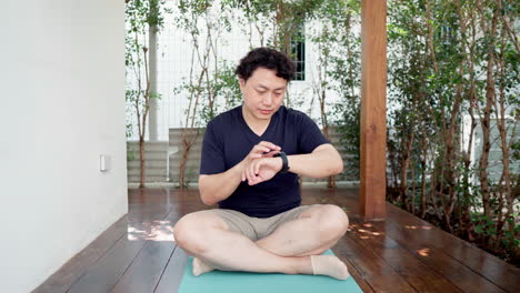 asian man looking at his smartwatch to monitor the heart rate