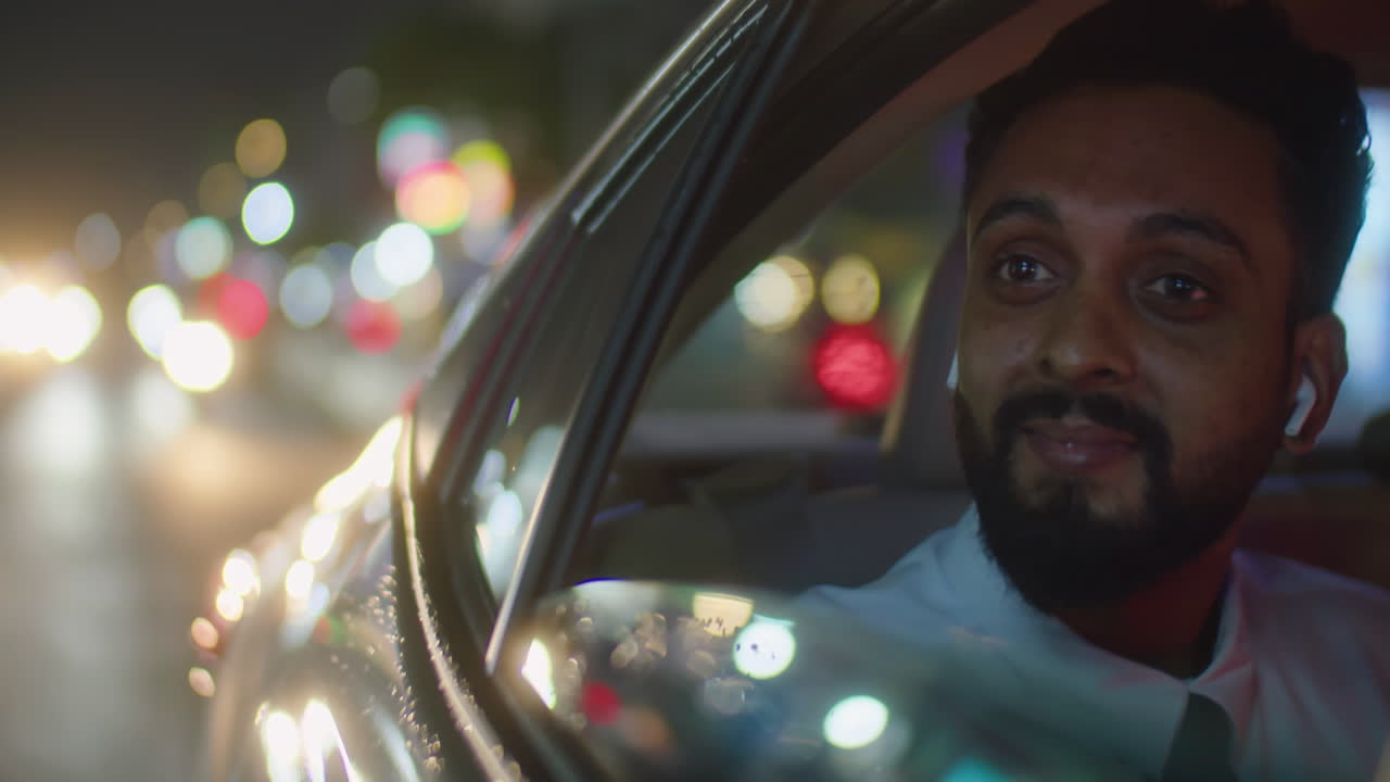 Businessman Enjoying Night City View during Car Ride