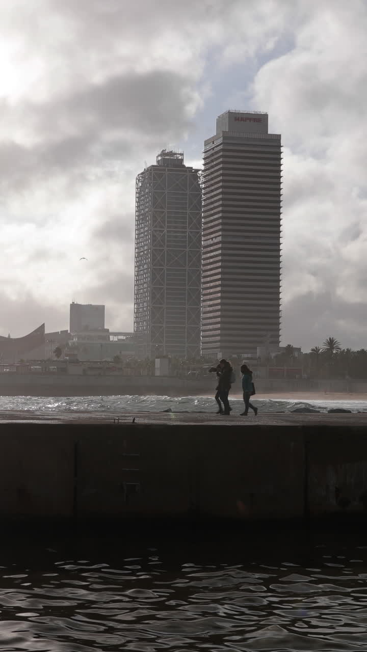 barcelona, españa - 31 de agosto de 2024: playa y costa de barcelona con los edificios en la sombra a última hora de la tarde en vertical.
