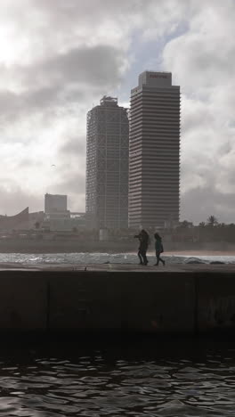 barcelona, spain - 31 august 2024 : barcelona beach and coastline with the buildings in shadow in late afternoon in vertical.