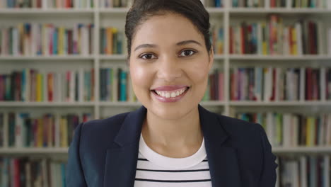 retrato de una mujer joven estudiante sonriendo estantería biblioteca universidad
