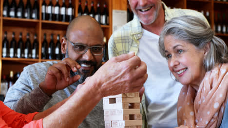 amigos felices jugando al juego de jenga mientras toman café 4k