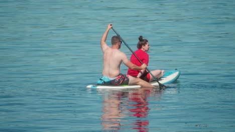 slow motion paddleboarding, couple fun leisure, water sports equipment