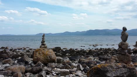 Ausgewogene-Spiritualität-Meditationskiesel,-Die-Auf-Einer-Fremden-Felsigen-Bergkette-Am-Strand-In-Der-Nähe-Der-Linken-Umlaufbahn-Aufgehäuft-Sind