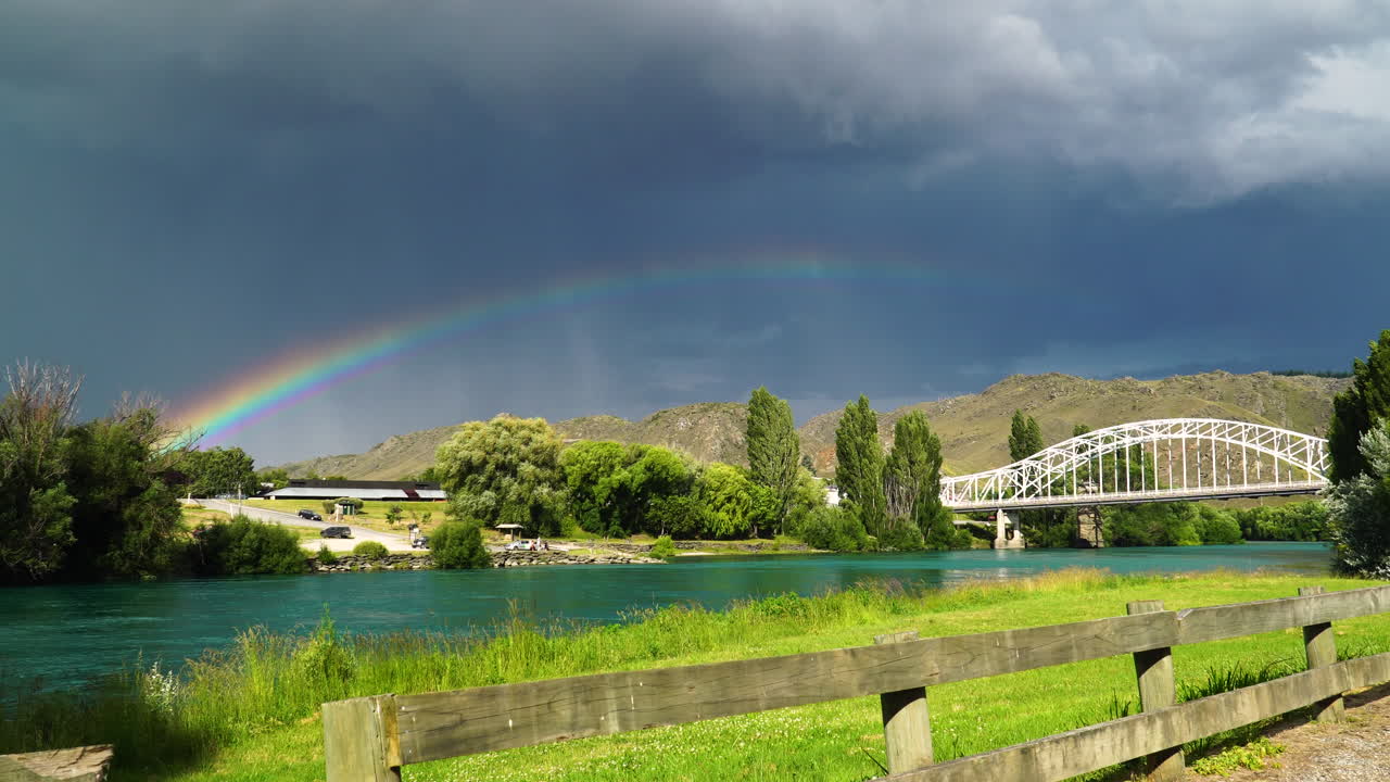 puente histórico, alexandra, nueva zelanda con nubes de tormenta y arco iris