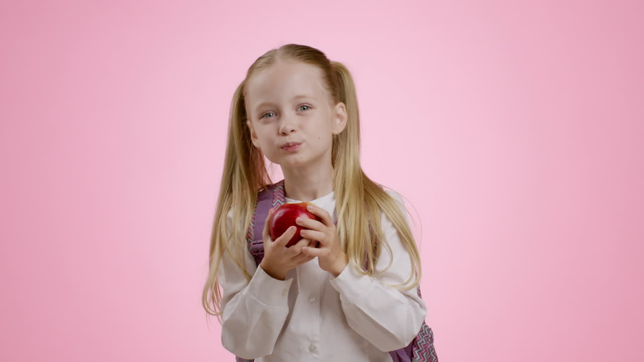 Девушка ест яблоко.