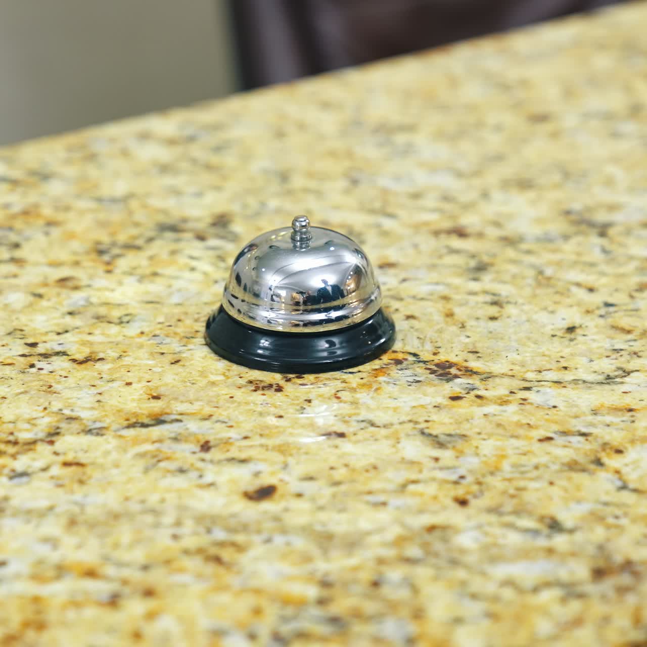 Bell on reception at the hotel to call the administrator. Beautiful blurred background. The hand of the man who presses the call. Concept for hotels