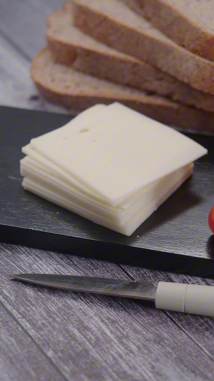 Pane a fette, formaggio e pomodorini su un tavolo di legno