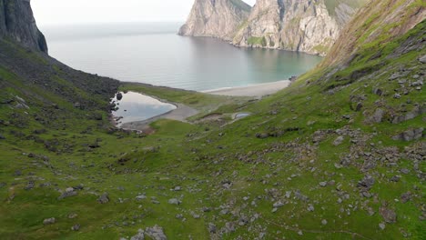 aerial shot of remote lofoten sandvika beach in noway surrounded by steep cliffs