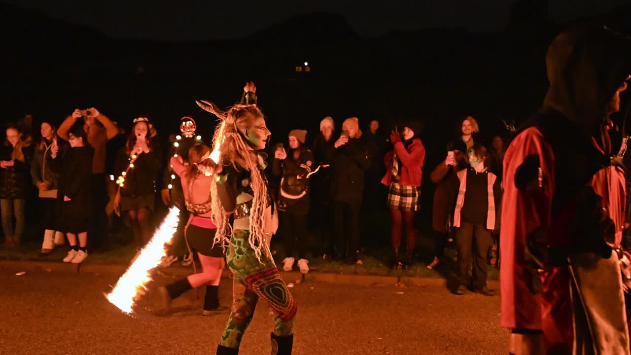 Horned woman performer spins fire snakes poi, Edinburgh Samhain festival