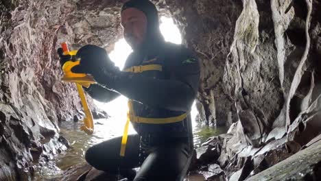 man in wetsuit exploring a sea cave