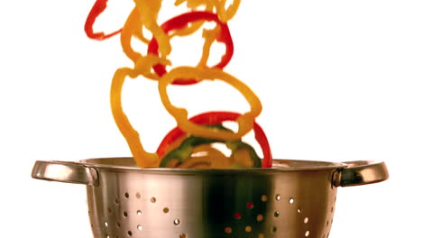 pepper slices falling into colander