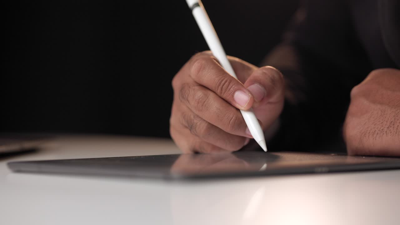 Businessman signing a business contract with stylus pen on tablet at night. Man signing contract on tablet at office. Business and technology concept. Electronic signature concept