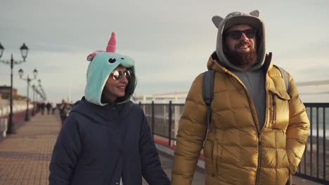 couple walking hand-in-hand on a pier