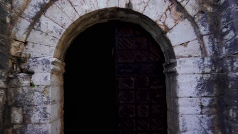 Arched-gate-of-medieval-castle-with-beautiful-stone-walls,-entering-inside-fortress