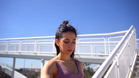 mujer deportista chequeando los latidos del corazón en un reloj inteligente en las escaleras urbanas