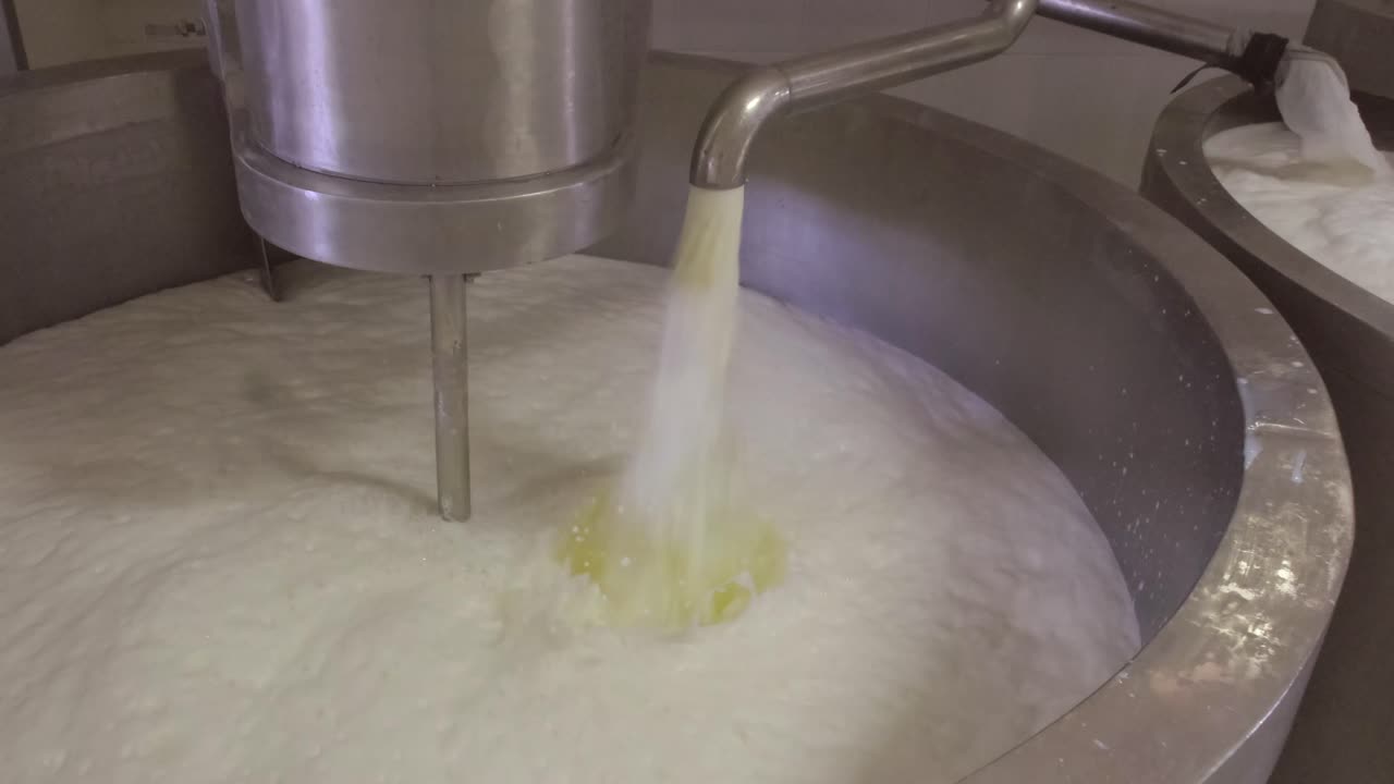 Milk pouring into the boiler at the cheese production plant