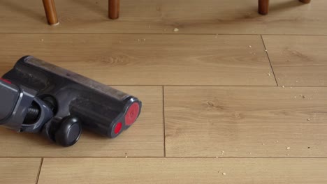 vacuuming a wooden floor with crumbs