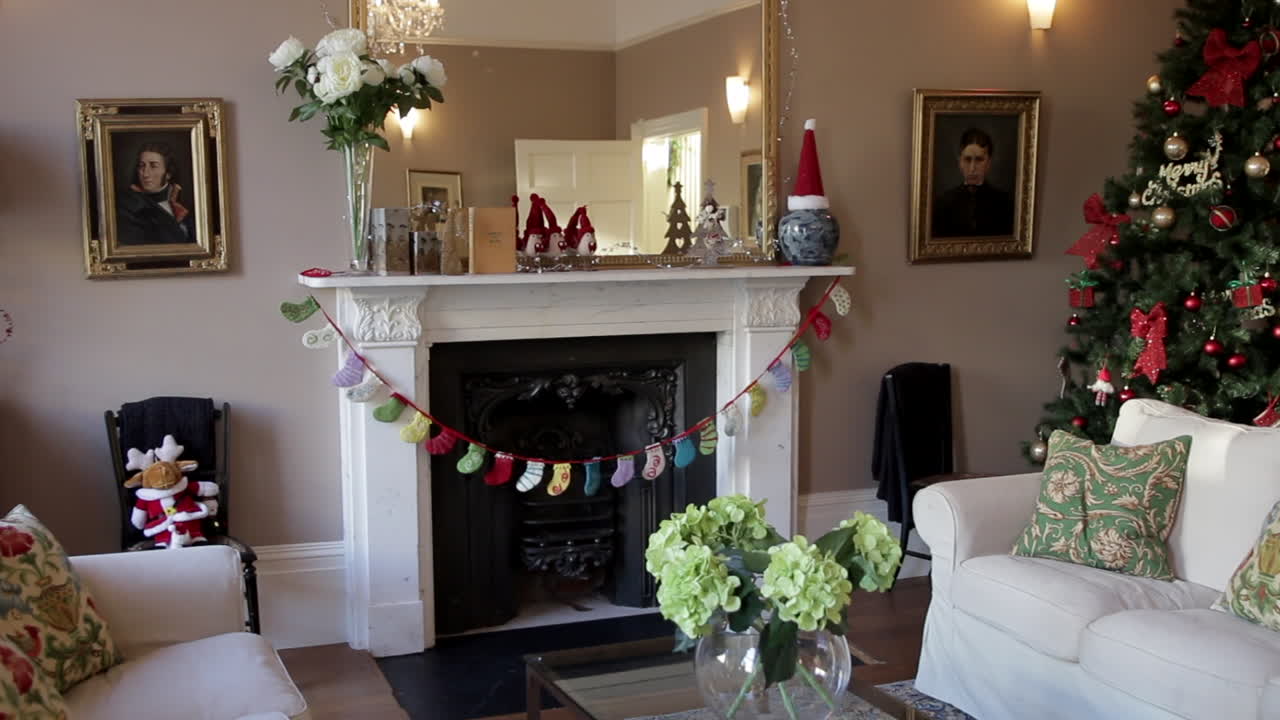 chimenea en una casa bellamente amueblada con adornos navideños, incluido un árbol de navidad en la esquina