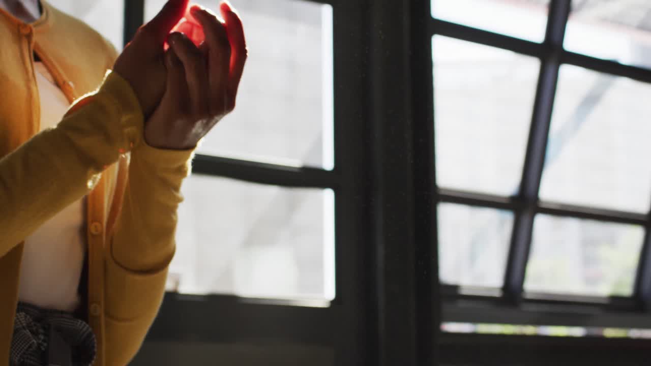 얼굴 마스크를 쓰고 여성 동료의 손을 소독하는 혼성 인종 남성 카페 직원