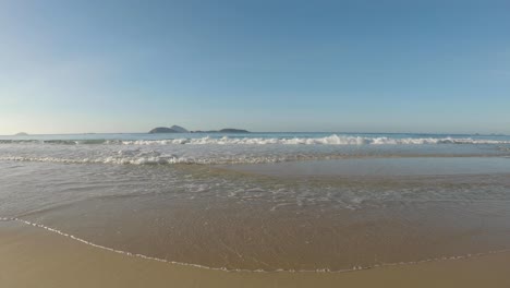 Paisaje-Marino-De-ángulo-Bajo-En-La-Costa-Atlántica-Con-Olas-De-Agua-Clara-Que-Llegan-Al-Amanecer-Con-Las-Islas-A-Las-Afueras-De-La-Playa-De-Ipanema-En-Río-De-Janeiro-En-El-Horizonte