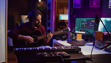 music producer tuning his acoustic guitar before playing instrument,