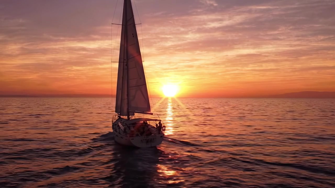 Un crucero sereno al atardecer: Capturando el viaje tranquilo de un velero deslizándose sobre aguas en calma mientras el sol se pone en el horizonte con colores vibrantes