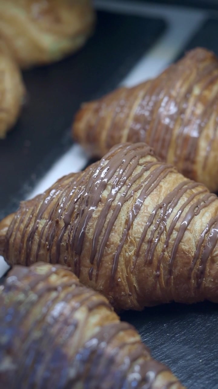 Freshly Baked Chocolate Drizzled Croissants on Display