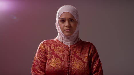 studio portrait of muslim woman wearing hijab against plain dark background 2